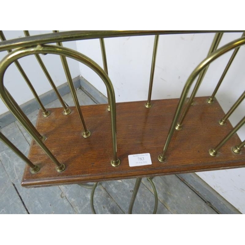 783 - An Edwardian oak and brass revolving magazine rack, on scrolled tripod supports with circular stretc... 