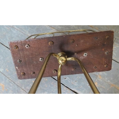 783 - An Edwardian oak and brass revolving magazine rack, on scrolled tripod supports with circular stretc... 