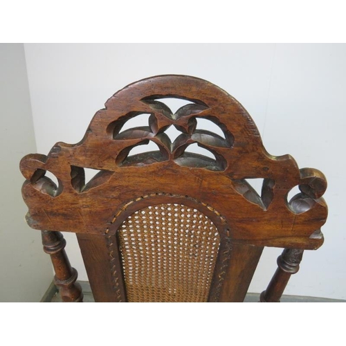 785 - A 17th century and later Carolean oak hall chair, the scroll carved and pierced cornice above a berg... 