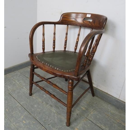 792 - An early 20th century elm captains desk chair, the turned spindles above a green seat with brass stu... 