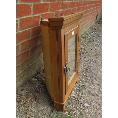 809 - An antique pine hanging corner cupboard, the door with inset mirror and brass latch opening onto a p... 