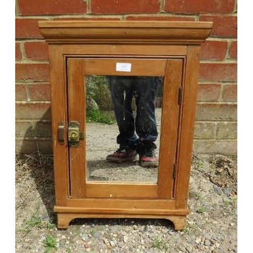 809 - An antique pine hanging corner cupboard, the door with inset mirror and brass latch opening onto a p... 