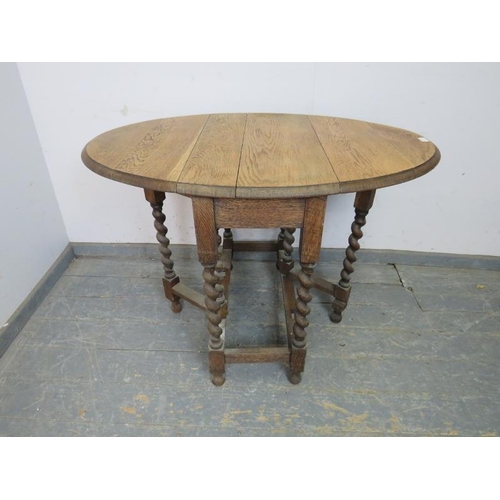 814 - An antique light oak gate-leg table, on barley twist supports with stretchers, raised on ball feet. ... 