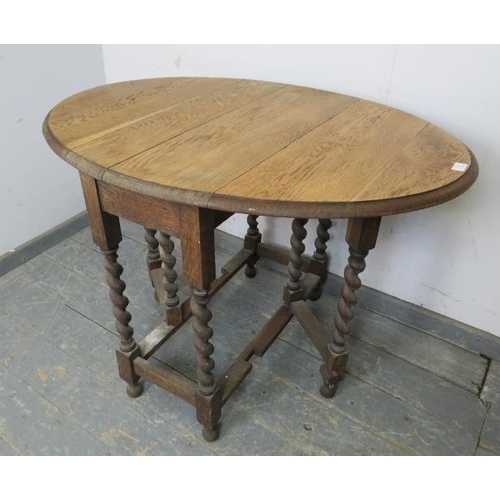 814 - An antique light oak gate-leg table, on barley twist supports with stretchers, raised on ball feet. ... 