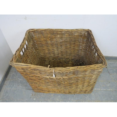 832 - A large vintage woven willow log basket, with pierced handles to either side.
H62cm W84cm D67cm (app... 