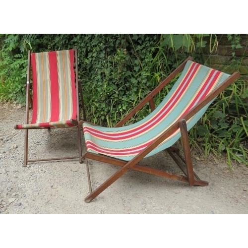 847 - A pair of vintage folding deckchairs, the beech frames with multicoloured striped canvas seats. 
H84... 