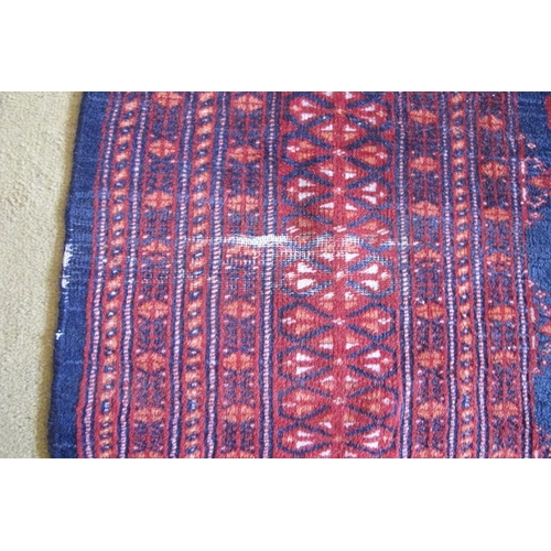 869 - A Persian Bokhara rug with a central repeat pattern on blue ground.  200cm x 129cm (approx)  Conditi... 