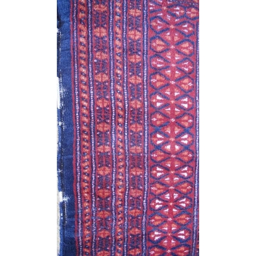 869 - A Persian Bokhara rug with a central repeat pattern on blue ground.  200cm x 129cm (approx)  Conditi... 