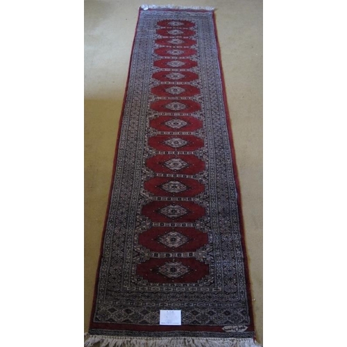 872 - Mid - late 20th Century Indian runner, 15 central panels on red ground. 305cm x 79cm (approx).
Condi... 