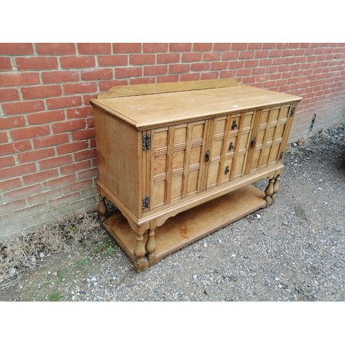 740A - An antique light oak sideboard in the Jacobean Revival taste, housing three graduated drawers flanke... 