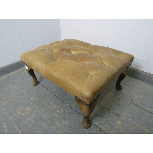 720A - An antique style footstool, upholstered in buttoned tan leather with brass studs, on cabriole suppor... 