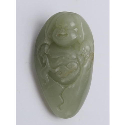 33 - A Chinese celadon jade laughing Buddha of pebble form and a lapis lazuli carved pendant plaque, 20th... 