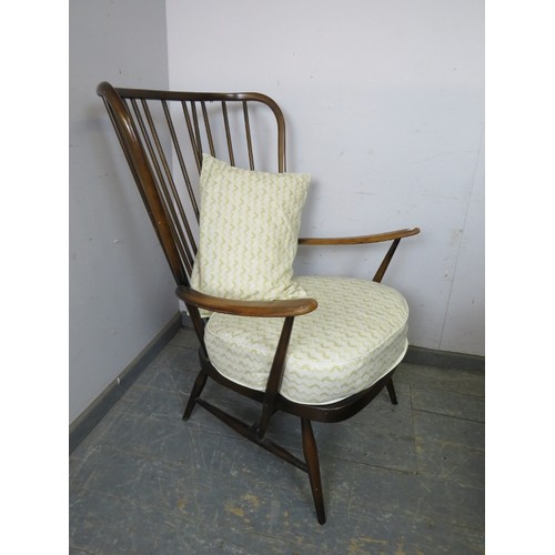 830A - A mid-century elm & beech wingback easy chair by Ercol, the loose scatter cushion and seat squab re-... 