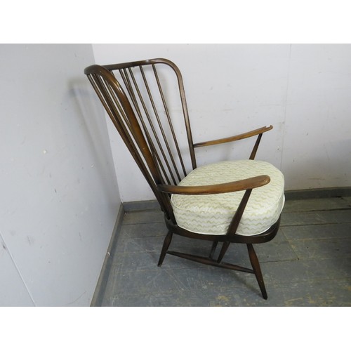 830A - A mid-century elm & beech wingback easy chair by Ercol, the loose scatter cushion and seat squab re-... 