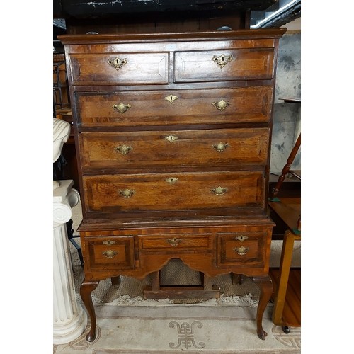 764 - An early Georgian medium oak and walnut chest on stand, the top housing two short and three long gra... 