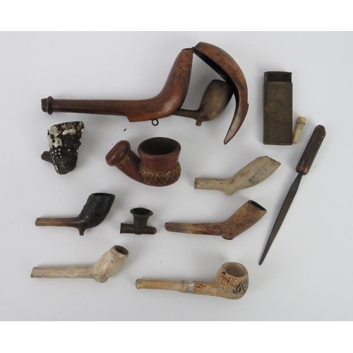 107 - Tobacconalia: A group of antique pipes and related articles. Notable items include a pipe bowl model... 