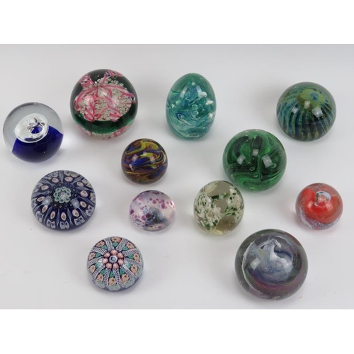 116 - A group of twelve British and European glass paperweights, mid/late 20th century. Two latticino glas... 