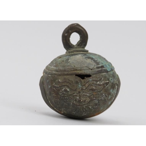 19 - A Burmese bronze buffalo bell, 19th century. Similar in form to a crotal bell, decorated with masks ... 