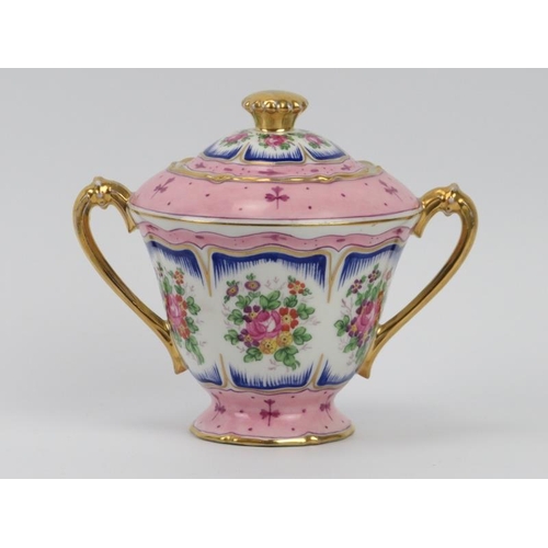 24 - A French Limoges twin handled urn and cover, 20th century. Gilt and florally decorated. 15 cm height... 