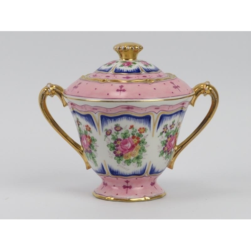 24 - A French Limoges twin handled urn and cover, 20th century. Gilt and florally decorated. 15 cm height... 