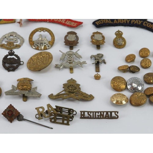 37 - Militaria: A collection of mainly WWI and WWII period British military cap badges, buttons and relat... 