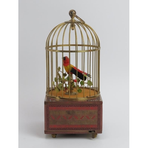 5 - A singing automaton bird in a cage, 20th century. The case supported on a champleve enamel decorated... 