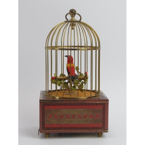 5 - A singing automaton bird in a cage, 20th century. The case supported on a champleve enamel decorated... 