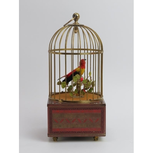 5 - A singing automaton bird in a cage, 20th century. The case supported on a champleve enamel decorated... 