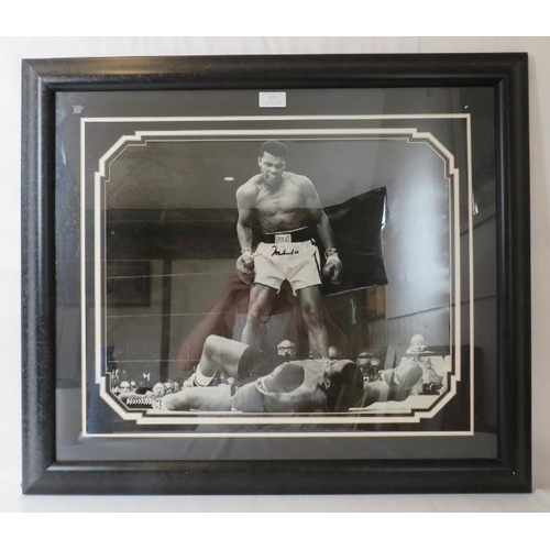 553 - Muhammad Ali Memorabilia. Framed and glazed enlarged photograph, signed by Muhammad Ali, with certif... 