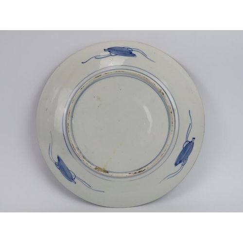 64 - A Chinese blue and white porcelain dish, late 19th/early 20th century. Decorated with a mountainous ... 