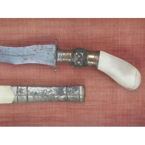 72 - An Indonesian gilt metal and bone ceremonial short sword and scabbard. Of larger, similar form to a ... 