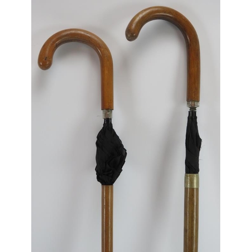 75 - Two umbrella walking canes, a carved wood walking cane, an ebonised walking cane with silver mounted... 