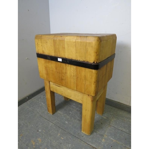 703 - An early 20th century beech butcher’s block of small proportions with iron strapwork banding, on squ... 