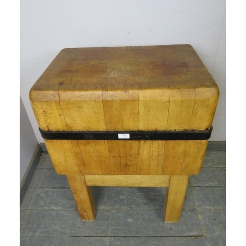 703 - An early 20th century beech butcher’s block of small proportions with iron strapwork banding, on squ... 