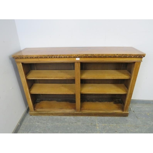 736 - A 19th century figured walnut low bookcase, housing four height adjustable open shelves, on a plinth... 