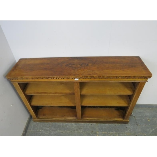 736 - A 19th century figured walnut low bookcase, housing four height adjustable open shelves, on a plinth... 