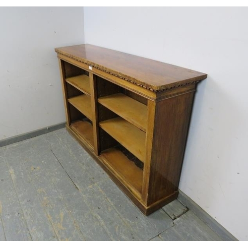 736 - A 19th century figured walnut low bookcase, housing four height adjustable open shelves, on a plinth... 