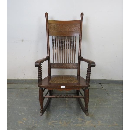 753 - An Arts & Crafts Period oak rocking chair, the backrest with relief carved foliate decoration and tu... 