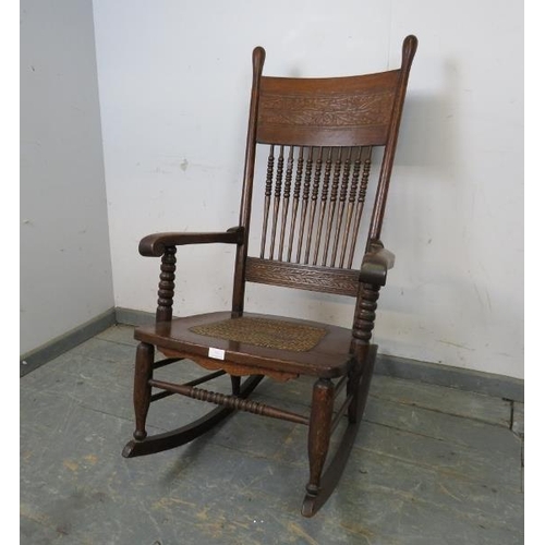 753 - An Arts & Crafts Period oak rocking chair, the backrest with relief carved foliate decoration and tu... 