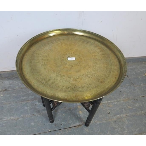 757 - A vintage Benares table, the brass tray top with engraved decoration in the Egyptian Revival taste, ... 