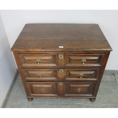 761 - A 17th century oak chest, housing three graduated long drawers with split geometric mouldings and fa... 