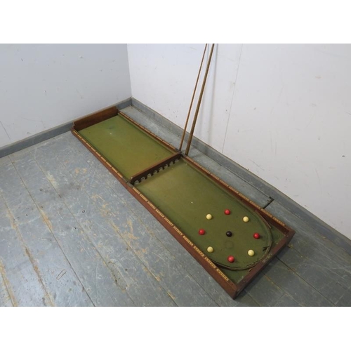 764 - An Edwardian mahogany folding bagatelle board, with baize lining. Includes balls, number markers, cu... 