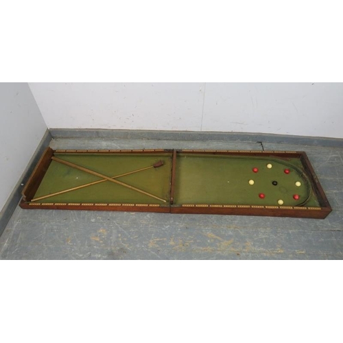 764 - An Edwardian mahogany folding bagatelle board, with baize lining. Includes balls, number markers, cu... 