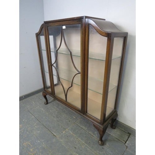 768 - An Art Deco Period walnut display cabinet, having shaped sides and tracery glazed door, housing two ... 