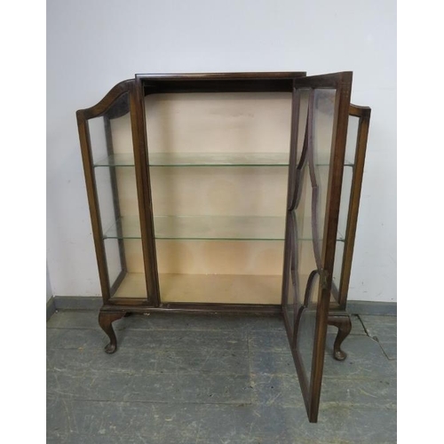 768 - An Art Deco Period walnut display cabinet, having shaped sides and tracery glazed door, housing two ... 