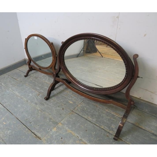 770 - Two turn of the century mahogany oval swing vanity mirrors, on scrolled supports. 
Largest H47cm W51... 