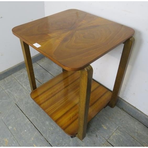 783 - An Art Deco period walnut two-tier table , the quarter veneered top with curved corners, on square s... 