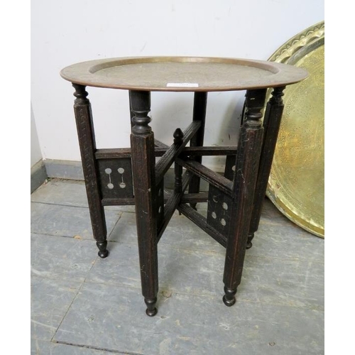 804 - An early 20th century Benares table, the hand-tooled brass tray top coloured and engraved, on a fold... 