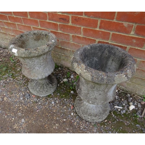 825 - A pair of weathered reconstituted stone garden urn planters with fluted decoration in the Classical ... 