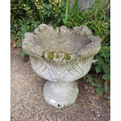 829 - A weathered reconstituted stone garden urn planter with relief moulded foliate decoration, on a plin... 